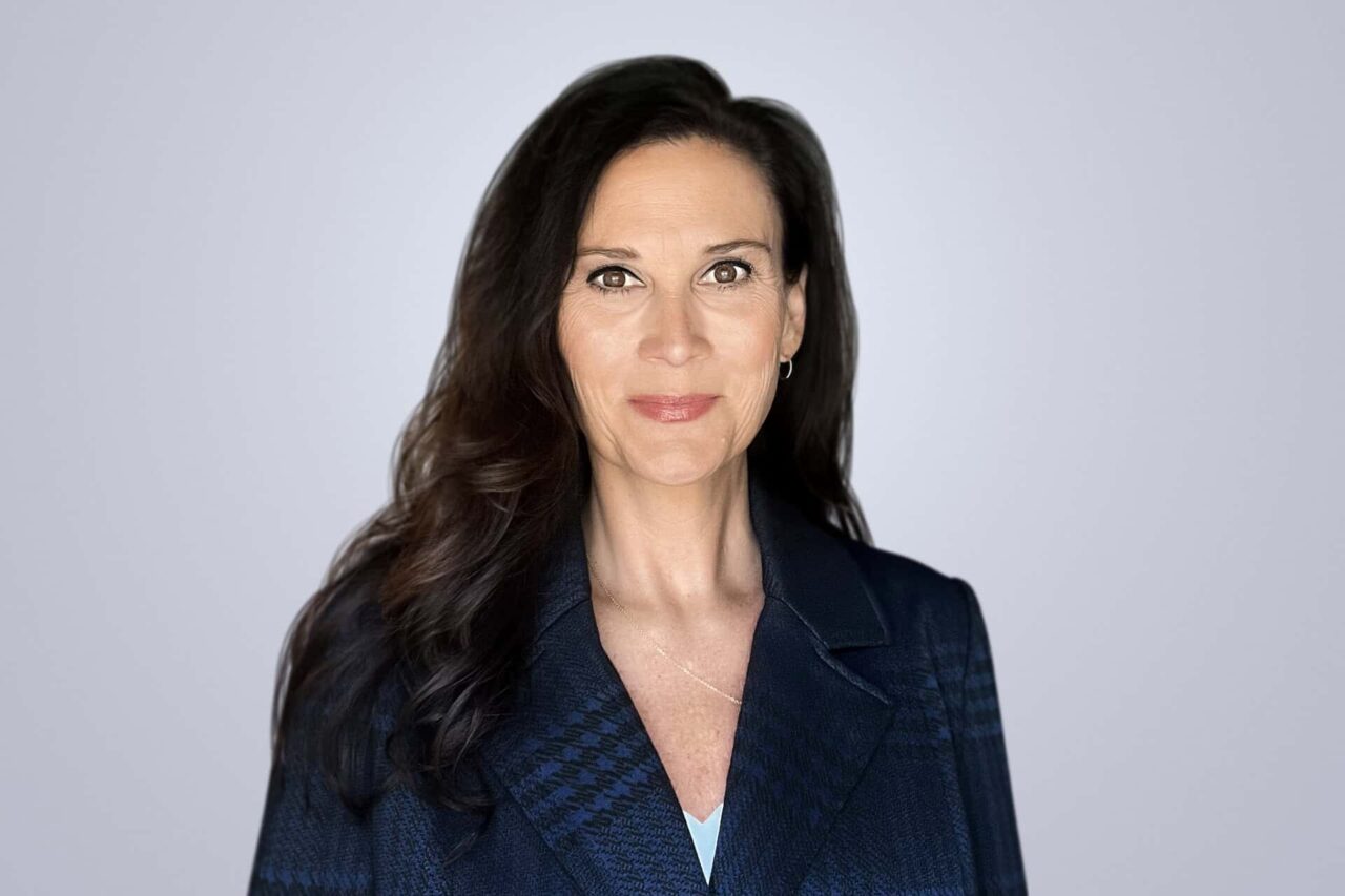 Professional woman in navy blazer helping manufacturers and end users grow through right connections.