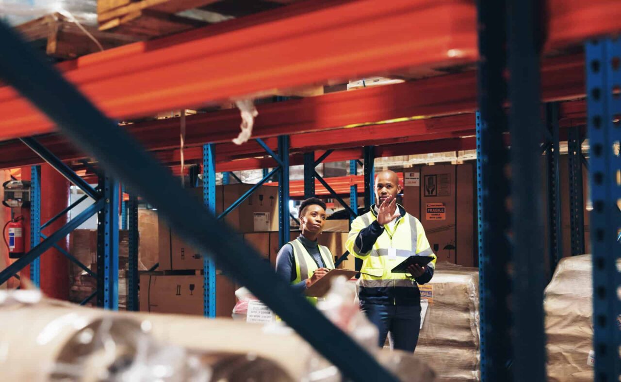 Warehouse workers in high-visibility vests assess logistics, enhancing trusted food service expertise.