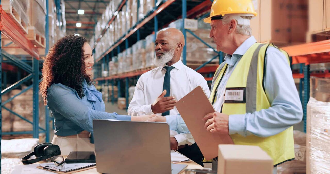 Distributors shaking hands with a trusted food service manufacturer’s representative in a warehouse, discussing how to grow your sales and product expertise.