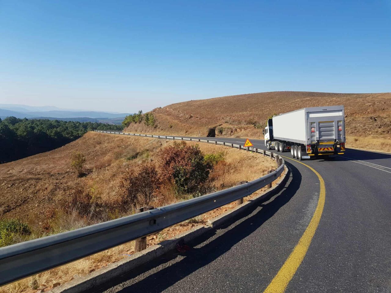 Truck on rural road, symbolizing efficient distribution by trusted food service manufacturers representatives.